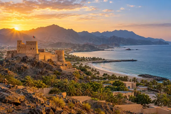 AI-generated illustration of Fujairah Fort, the Hajar mountains and the sea at sunrise