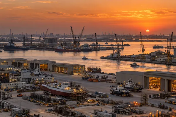 AI-generated illustration of shipyards and workshops in the Mussafah industrial area of Abu Dhabi at sunset